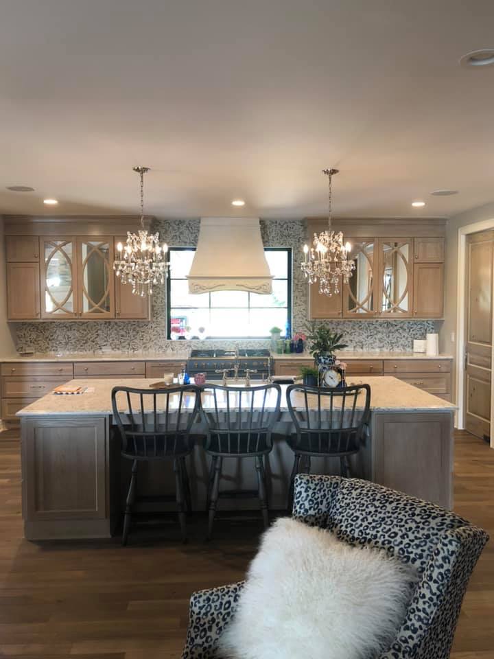 A modern kitchen featuring a central island with chairs, showcasing a clean and functional design suitable for cooking and dining.