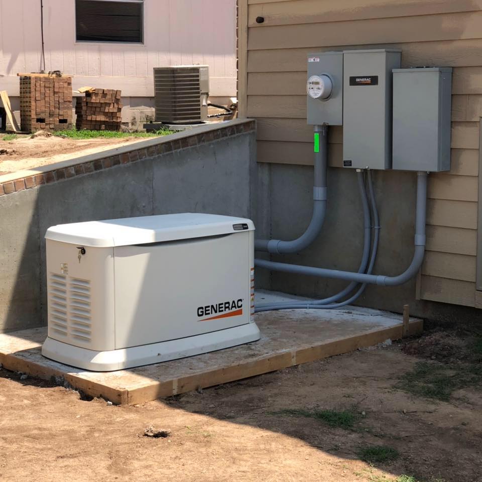 A generator positioned beside a house, indicating the presence of an electrician's work or installation.